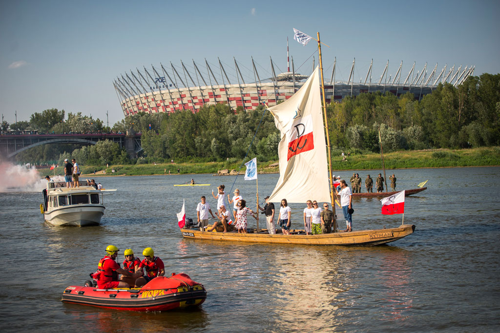 The W hour on the Vistula River, boat parade, in the background the Poniatowski Bridge, PGE National Stadium, trees, greenery, day, summer.