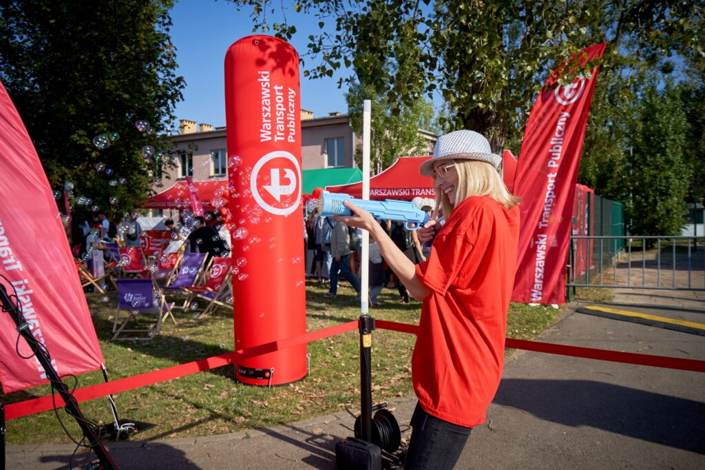 Zabawa podczas DTP: osoba w czerwonej koszulce i kapeluszu, dmuchany banner WTP